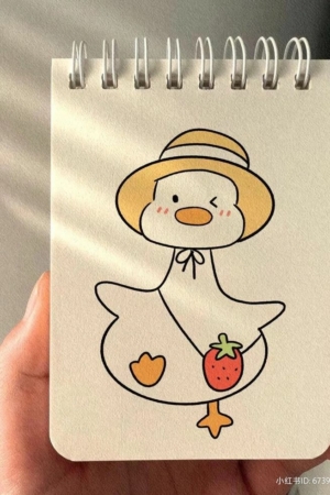 Uma mão segurando um caderno com um rabisco de um pato usando um chapéu e carregando um morango, exibindo desenhos caprichosos.