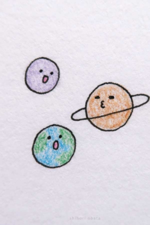 Para desenhar - Desenhar três planetas com expressões faciais, incluindo a Terra, Saturno e outro planeta roxo, resulta em desenhos simples e divertidos.