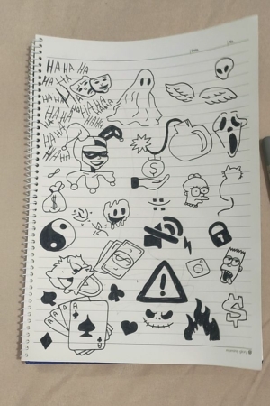 Página de caderno preenchida com vários Desenhos de cria em tinta preta, incluindo fantasmas, emojis, cartões e símbolos. Caneta colocada ao lado do caderno fácil. Para Colorir.