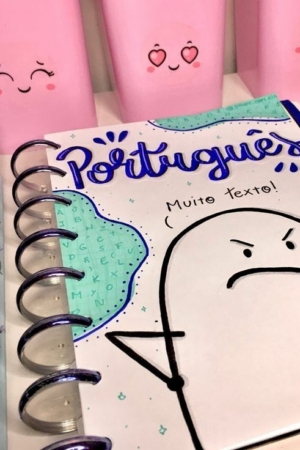 Caderno com capa de caderno com desenho em português, cercado por marcadores em tons pastéis e recipientes fofos e emotivos.