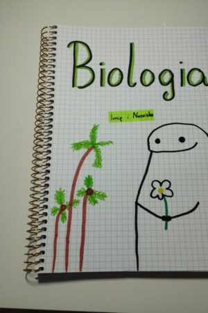 Capa do caderno de biologia com um desenho de uma figura sorridente segurando uma flor, com palmeiras ao lado.