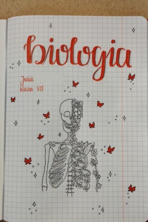 Página de caderno com "biologia" escrito no topo, com um desenho detalhado de esqueleto e borboletas vermelhas ao redor. A capa do caderno é igualmente intrigante, exibindo o mesmo desenho meticuloso.