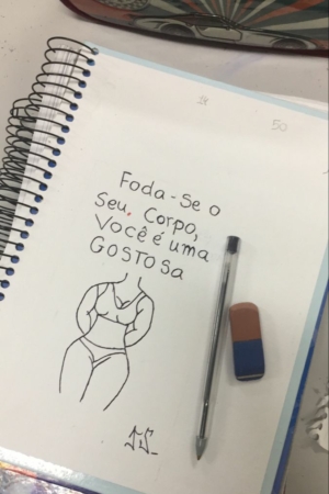 Um esboço de caderno de um corpo com texto em português, ao lado de uma caneta e borracha no papel, criando um intrincado fazer desenho no caderno. Para desenhar.