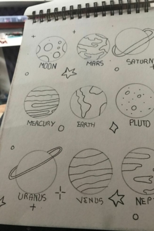 Uma página de caderno com desenhos simples de planetas rotulados como Lua, Marte, Saturno, Mercúrio, Terra, Plutão, Urano, Vênus, Netuno. Para desenhar.