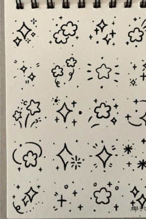 Uma página de caderno de desenho repleta de rabiscos feitos à mão de estrelas, brilhos e nuvens em tinta preta, capturando a essência caprichosa de um caderno de desenho onírico. Para desenhar.