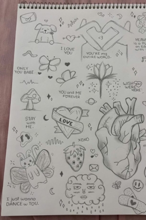 Uma página de caderno cheia de vários desenhos, incluindo um coração, caveiras, folhas e frases como "EU TE AMO" e "FIQUE COMIGO", todos desenhados de forma complexa em um caderno. Para desenhar.