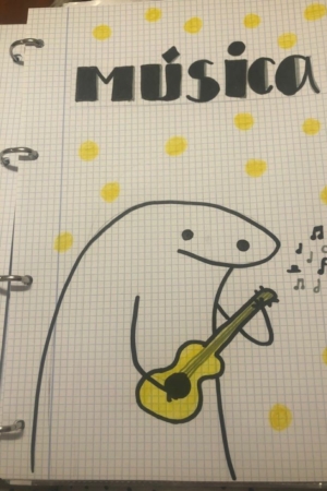 Um personagem de desenho animado tocando uma guitarra amarela preenche uma página intitulada "música", com notas musicais e bolinhas amarelas, lembrando um desenho lúdico na capa do caderno.